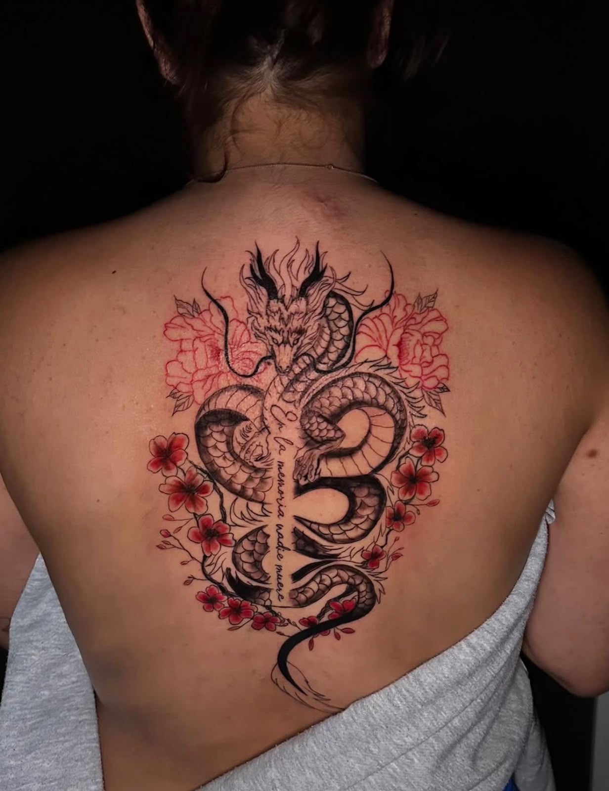 Tatuaje a color de dragón y flores